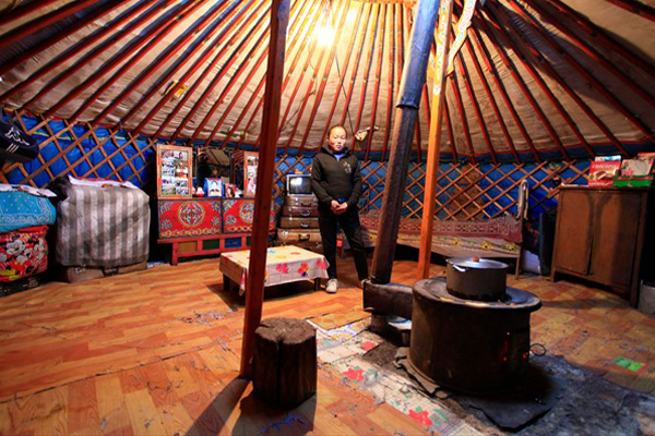 Mongolian woman inside tent with stove